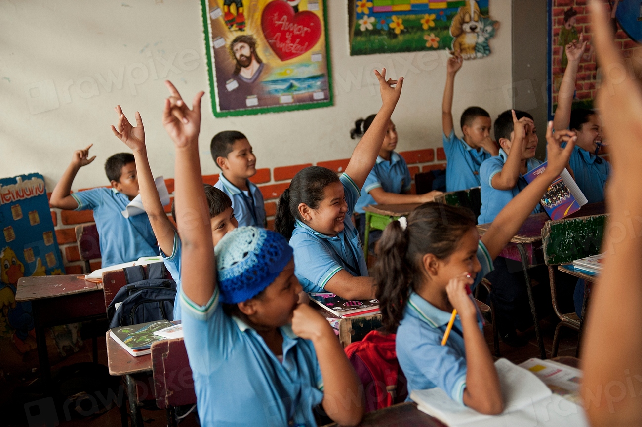 Estudiantes de un colegio en Colombia levantan la mano para participar